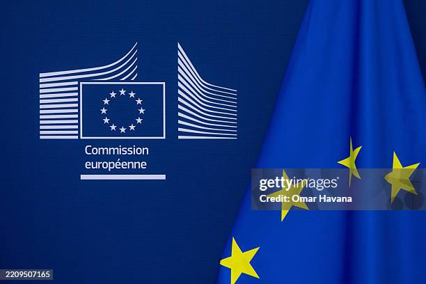 The logo of the European Commission is seen printed on a wall of the VIP lounge next to a European flag at the EU headquarters on April 10, 2025 in...