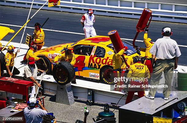 Crew members service Bobby Hamilton's Chevrolet on pit road as NASCAR officials watch on during the NASCAR MBNA Platinum 400 at Dover Downs...