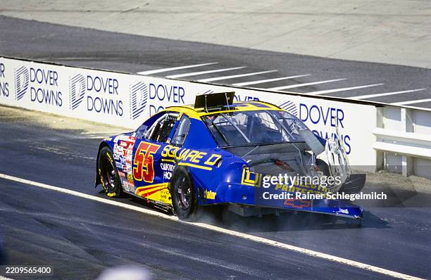 Kenny Wallace drives his heavily damaged APR Chevrolet down pit road after a crash during the NASCAR MBNA Platinum 400 at Dover Downs International...