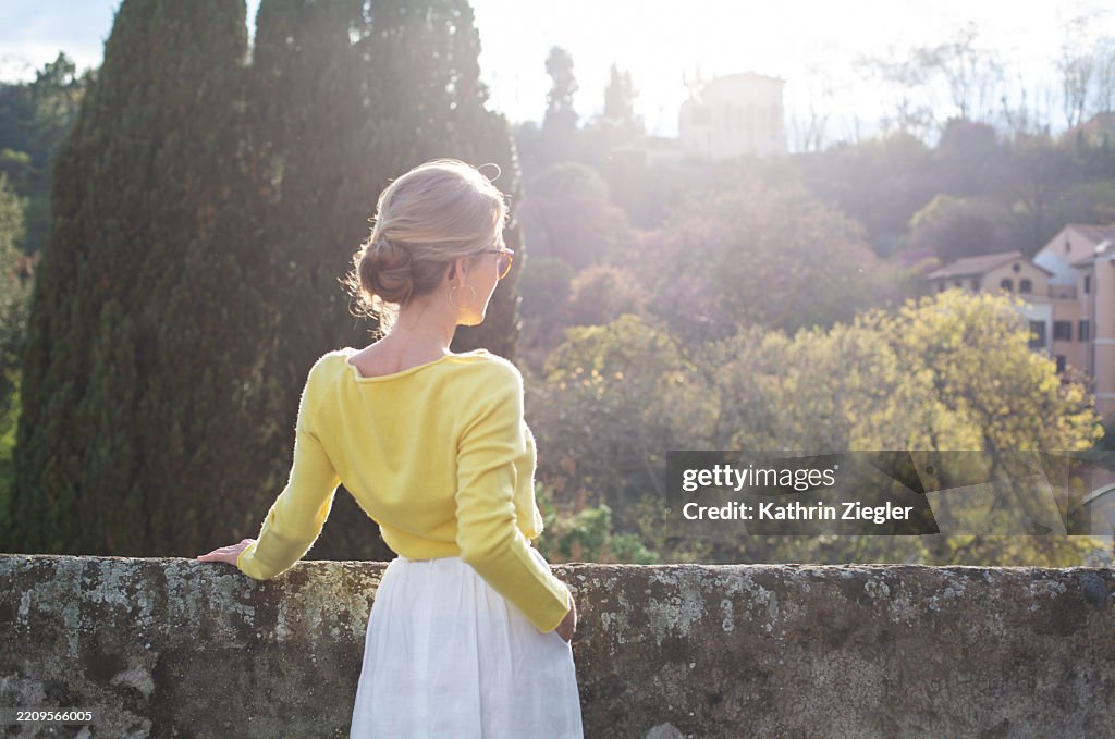 Woman enjoying the view from rooftop terrace in sweet afternoon light