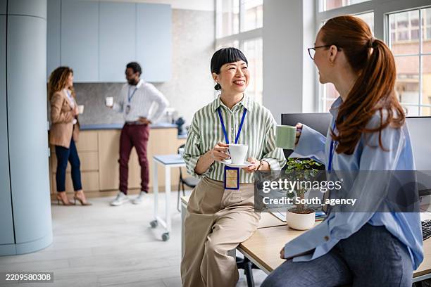 spannende diskussionen und teamarbeit zwischen verschiedenen fachleuten in einer modernen büroumgebung - kaffeepause stock-fotos und bilder