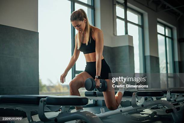 sportive déterminée effectuant des fentes avec des haltères en salle de sport - jambe photos et images de collection