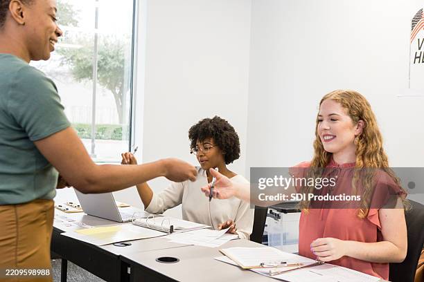 voter registration: women helping people vote - local government building stock pictures, royalty-free photos & images