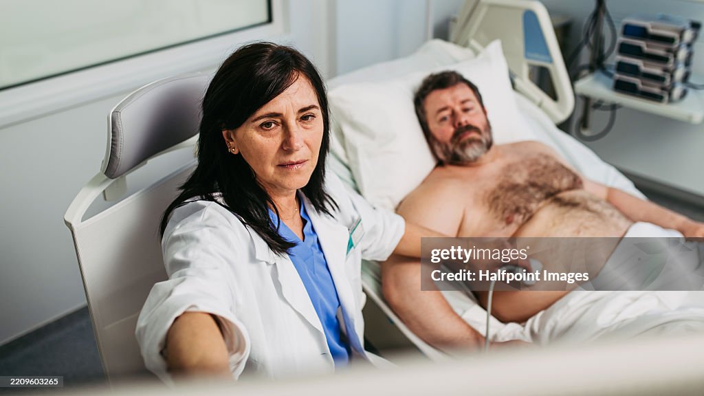 Female doctor performing an ultrasound on male patient's abdomen