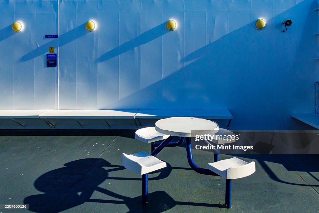 A ferry deck, fixed seating and a round table