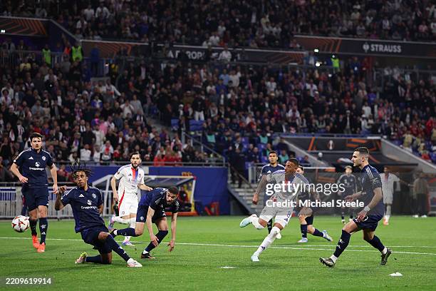 Corentin Tolisso of Olympique Lyonnais shoots and misses as Leny Yoro of Manchester United attempts to make a block during the UEFA Europa League...