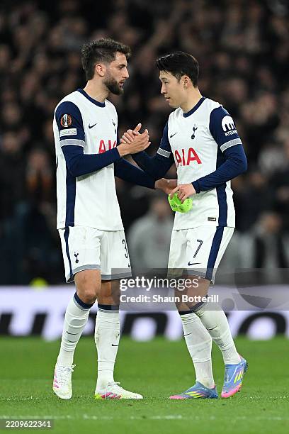 Son Heung-Min of Tottenham Hotspur shakes hands with Rodrigo Bentancur as he hands him the captains armband whilst leaving the field as he is...