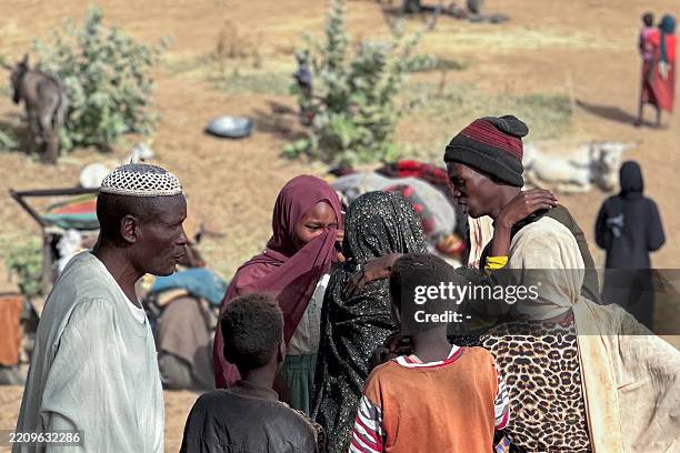People who fled the Zamzam camp for the internally displaced after it fell under RSF control, coomiserate in a makeshift encampment in an open field...