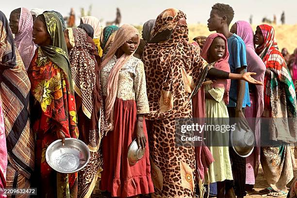 People who fled the Zamzam camp for the internally displaced after it fell under RSF control, queue for food rations in a makeshift encampment in an...