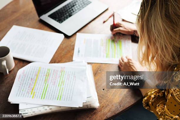 woman teacher grading student exams while working from home - teacher grading paper stock pictures, royalty-free photos & images