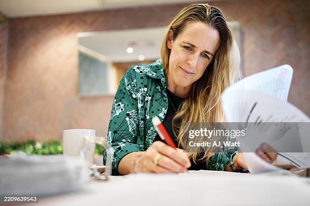 educator evaluating student exams in cafe workspace - rating stock pictures, royalty-free photos & images
