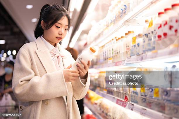 asian women buy milk, bread and fruit in the supermarket - soya milk stock pictures, royalty-free photos & images