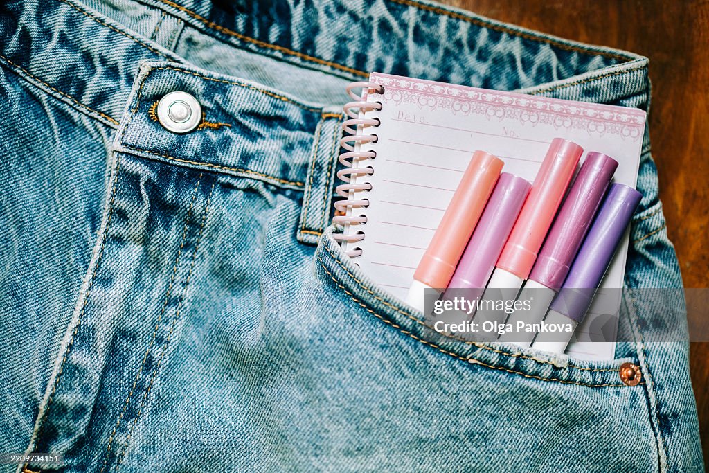 Colorful felt-tip pens and notebook in jeans pocket: ready for inspiration