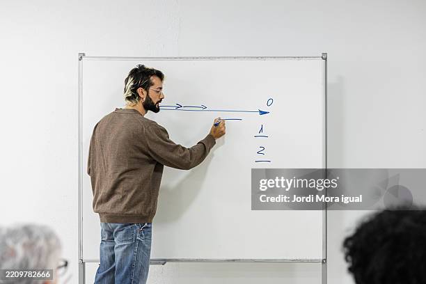 teacher explaining math formula on whiteboard to adult students - math problems stock pictures, royalty-free photos & images