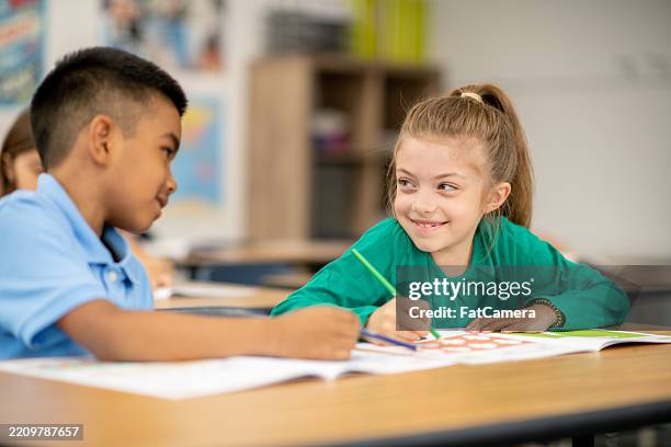 two students engaged in creative learning activities inside a classroom - worksheet stock pictures, royalty-free photos & images