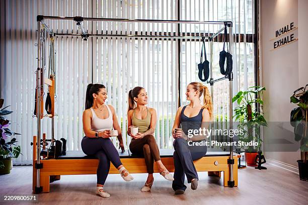 female pilates instructor talking with students in a bright studio - coffee gym stock pictures, royalty-free photos & images