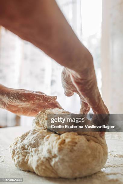 process of making dough for homemade bread by an elderly woman - kneading stock pictures, royalty-free photos & images