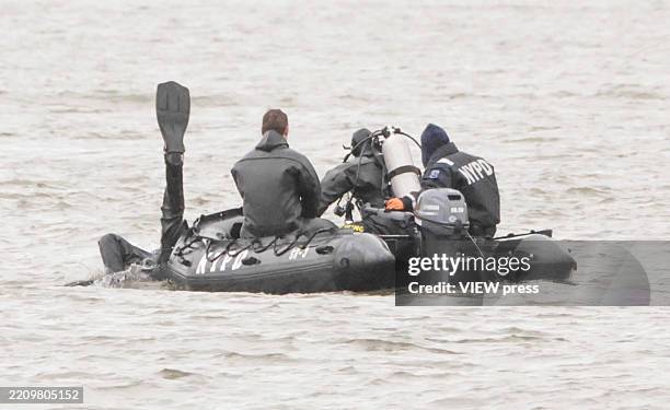 Divers work on the scene where a helicopter crashed on the Hudson River on April 11, 2025 in Jersey City, New Jersey. Six people were killed when a...