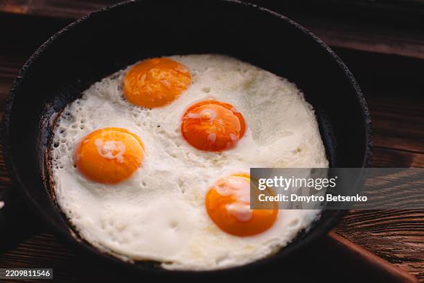 fried eggs in a frying pan on a wooden rustic window sill - sunny side up stock pictures, royalty-free photos & images