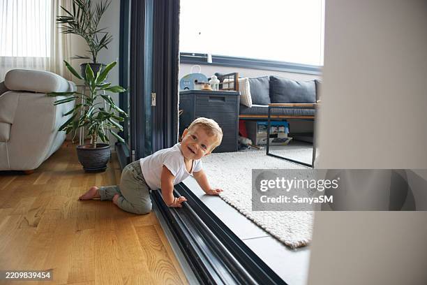 schöner, glücklicher baby junge spielt - krabbeln stock-fotos und bilder