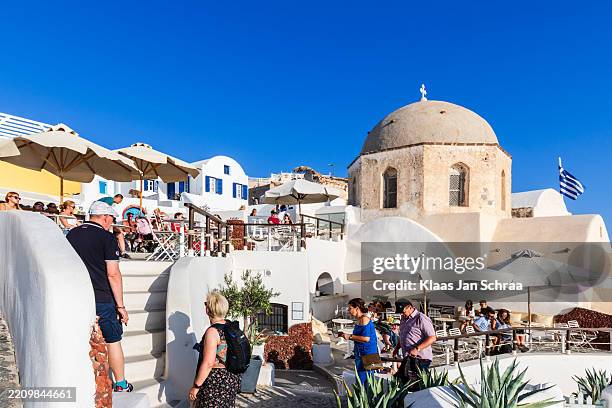 santorini, greece: tourists enjoying the sun on a terrace - egeu meridional imagens e fotografias de stock