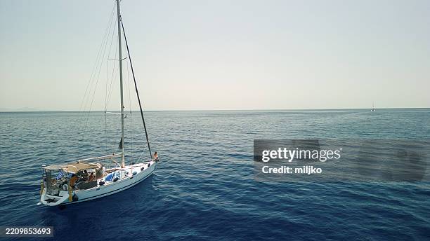barca a vela che naviga su mare calmo. ragazza adolescente è seduta sull'arco - albero maestro foto e immagini stock