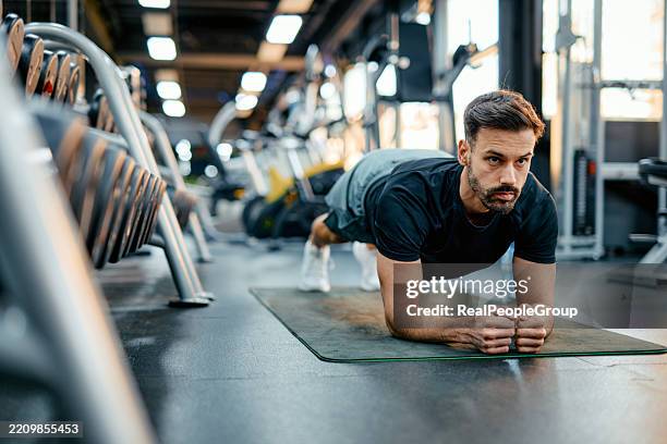 determined athlete performing plank exercise on gym mat - clean gym equipment stock pictures, royalty-free photos & images