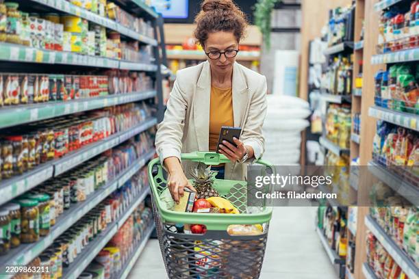 woman shopping in supermarket. - buy online pick up in store stock pictures, royalty-free photos & images
