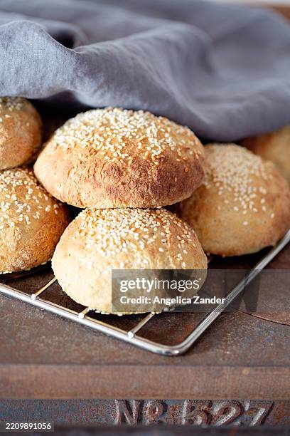 homemade sesame buns on cooling rack - sesame seed bun stock pictures, royalty-free photos & images
