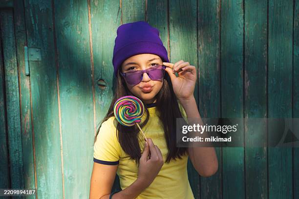 charming girl with lollipop and sunglasses - purple hat stock pictures, royalty-free photos & images