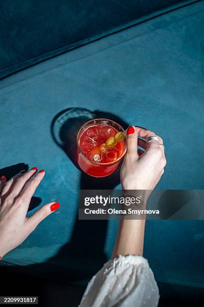 female hands hold a bright cocktail on a velvet background - alcohol free stock pictures, royalty-free photos & images