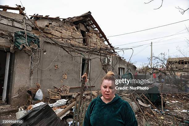 Woman stands among the rubble outside a house damaged by an overnight Russian drone attack in Odesa, Ukraine, on April 16, 2025. Russian troops...