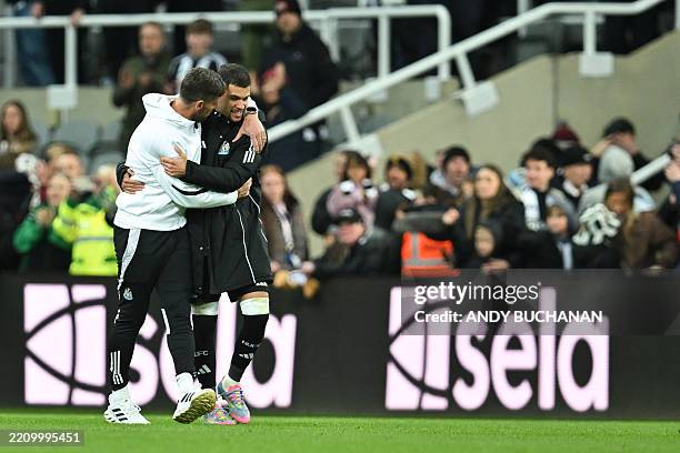 Newcastle United's assistant coach Jason Tindall congratulates Newcastle United's Brazilian midfielder Bruno Guimaraes at the end of the English...