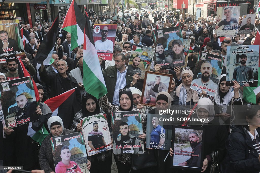 Palestinian protesters hold pictures of their relatives...