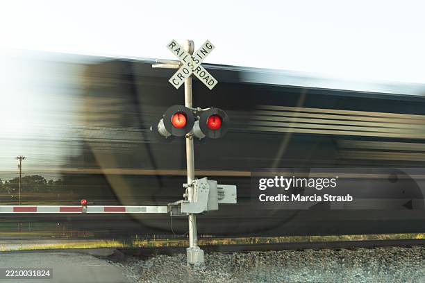 train speeding past railroad crossing - level crossing stock pictures, royalty-free photos & images