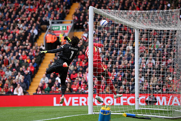 Alisson Becker of Liverpool tips the ball onto the crossbar after a shot from Mohammed Kudus of West Ham United during the Premier League match...