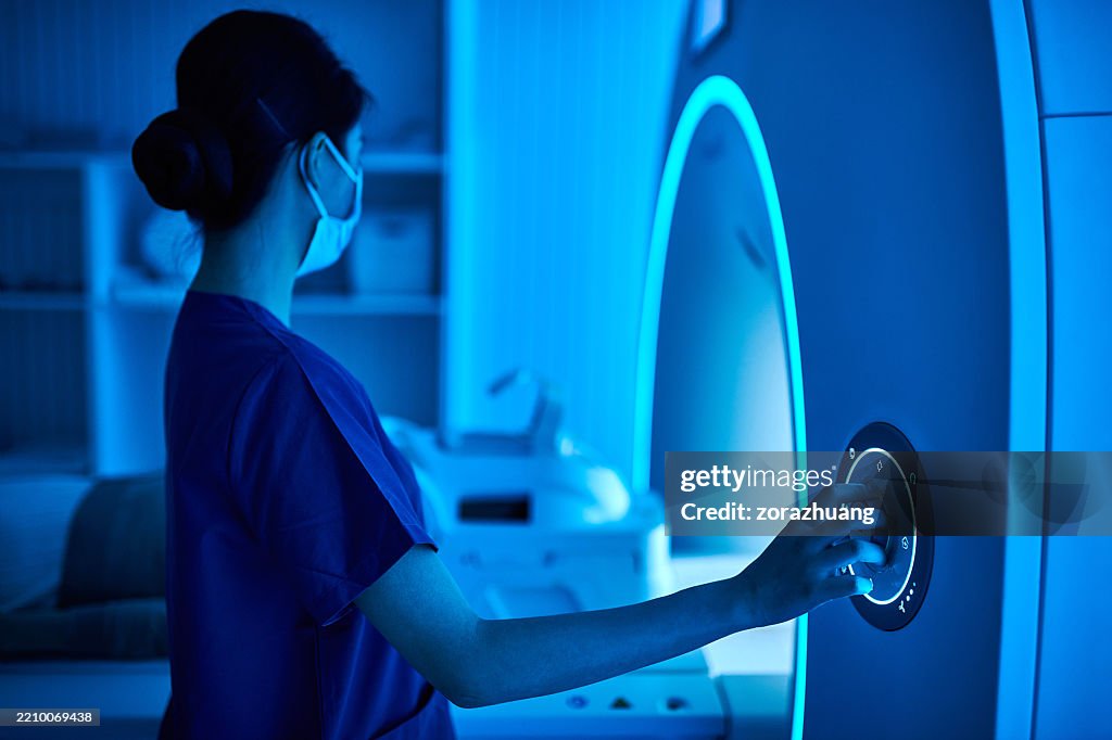 Infermiera che opera la macchina di scansione MRI nella sala scanner MRI