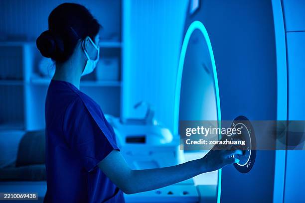 infermiera che opera la macchina di scansione mri nella sala scanner mri - apparecchiatura medica foto e immagini stock