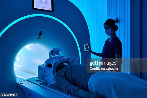 female nurse operating mri scan machine at mri-scanner room - pet scan stock pictures, royalty-free photos & images