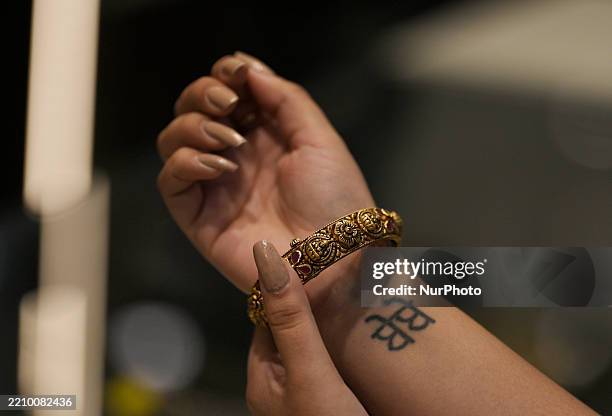 Woman poses with gold bangles at a Kalyan Jewellers showroom in Mumbai, India, on April 17, 2025. Gold prices in India and globally hit record highs...
