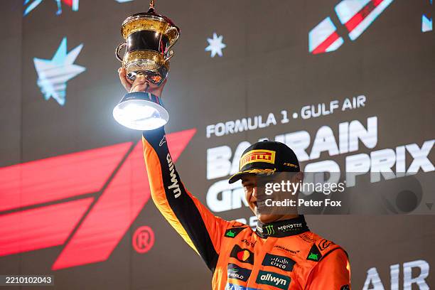 Third placed Lando Norris of Great Britain and McLaren lifts his trophy on the podium during the F1 Grand Prix of Bahrain at Bahrain International...