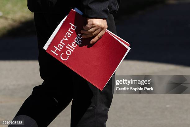 Person holds a Harvard College folder during a tour at Harvard University on April 17, 2025 in Cambridge, Massachusetts. The Trump administration...