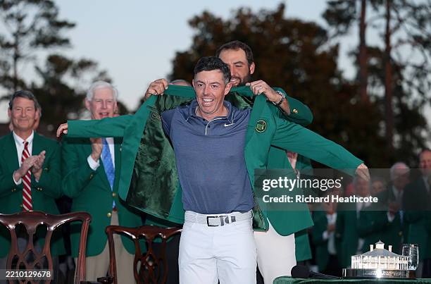 Rory McIlroy of Northern Ireland is awarded the Green Jacket by Masters Champion Scottie Scheffler after the final round of the 2025 Masters...
