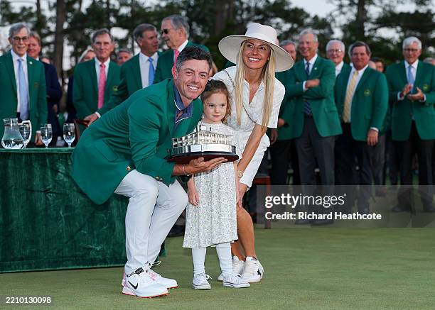 Rory McIlroy of Northern Ireland poses with daughter Poppy and wife Erica Stoll holding the Masters trophy during the Green Jacket Ceremony after...