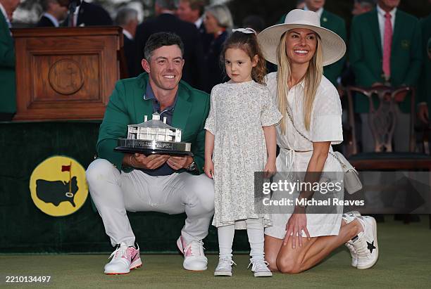 Rory McIlroy of Northern Ireland poses with daughter Poppy and wife Erica Stoll holding the Masters trophy during the Green Jacket Ceremony after...
