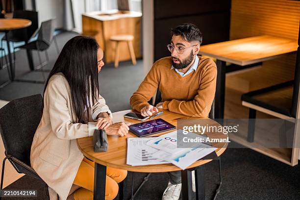 diverse investors discussing financial strategies - marktonderzoek stockfoto's en -beelden