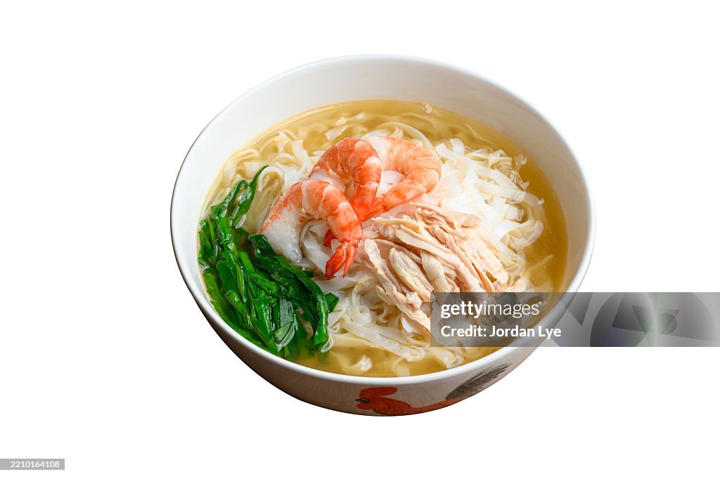 Bowl of flat rice noodle in soup with shredded chicken on white background