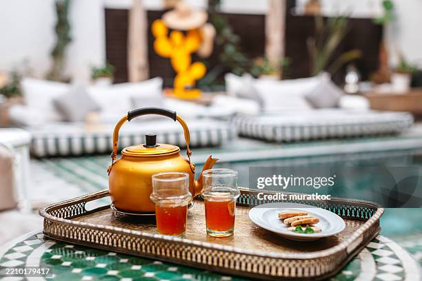 moroccan mint tea served by the poolside in a peaceful courtyard riad - marrakech stockfoto's en -beelden