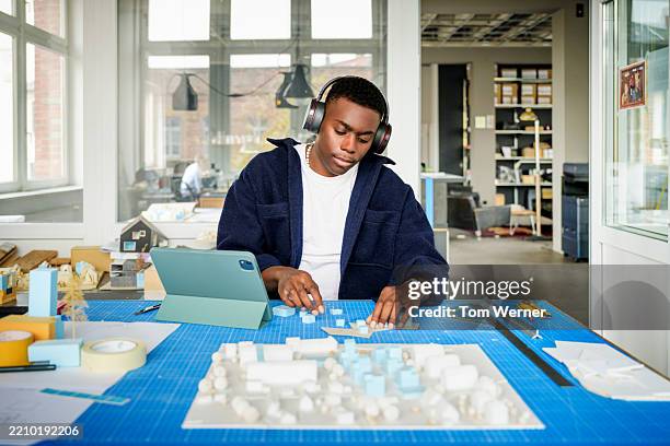 young architect using tablet and model to focus on architectural model design - mobile tablet on table stock pictures, royalty-free photos & images