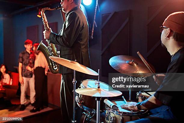 saxofonista y baterista de jazz en el escenario de una discoteca - tocar un instrumento fotografías e imágenes de stock
